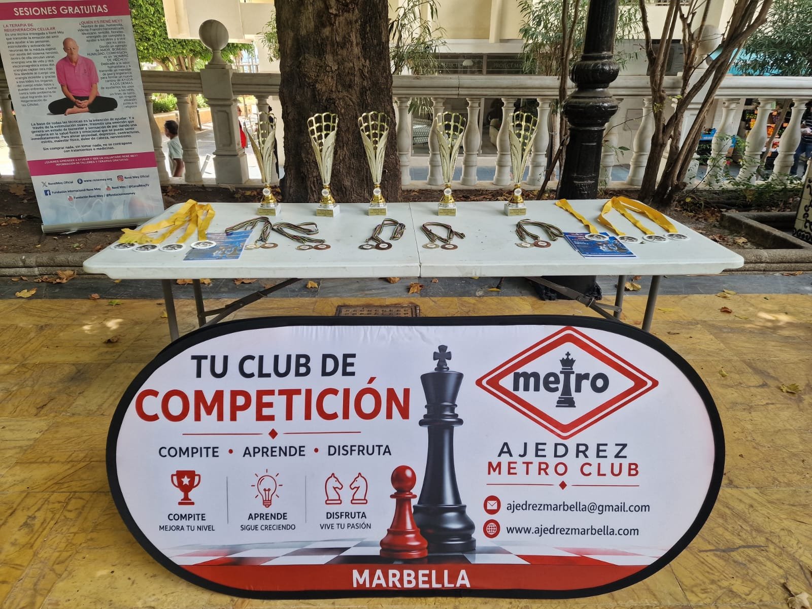 Trofeos y medallas del Torneo de Ajedrez World Wellness Weekend 2026 junto al cartel de Ajedrez Metro Club